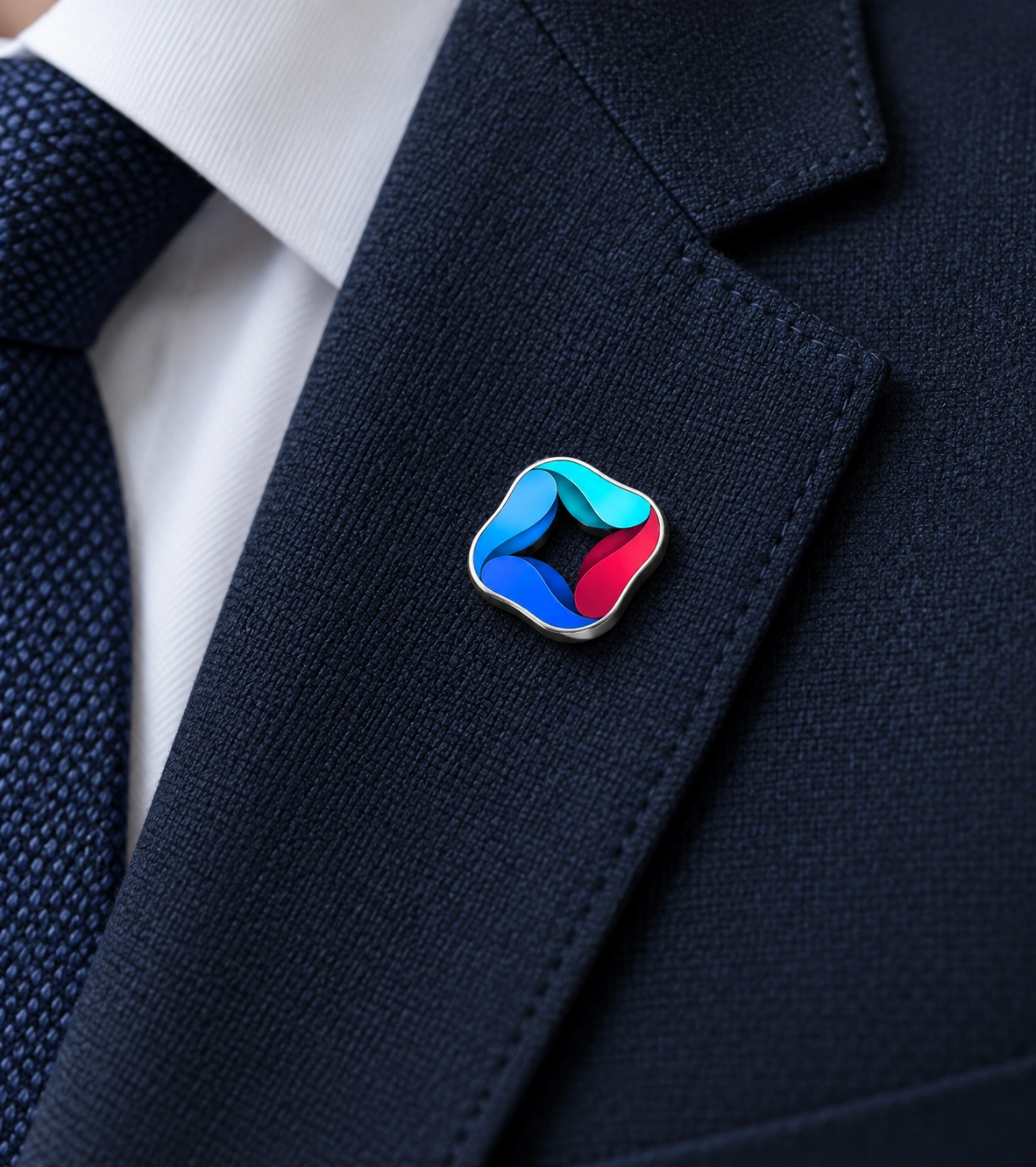 ONE GML enamel and polished silver lapel pin on a navy suit.